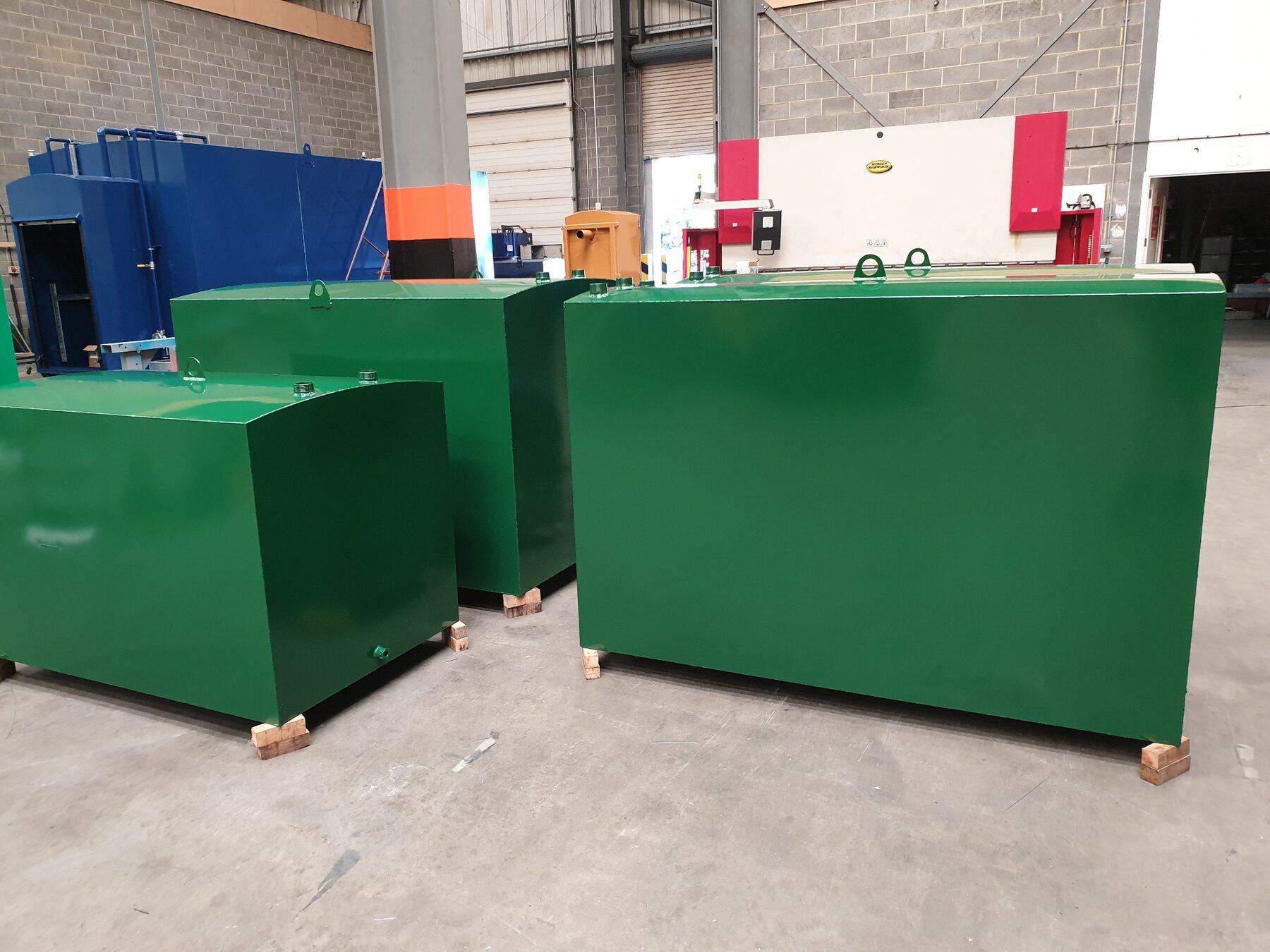 A row of bespoke green steel domestic oil tanks in the Terence Barker factory